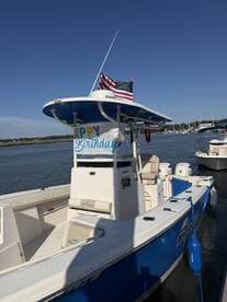 A vibrant view of a Sea Chaser boat adorned with a 'Happy Birthday' banner, docked in calm waters — perfect for celebrating special occasions on the water.
