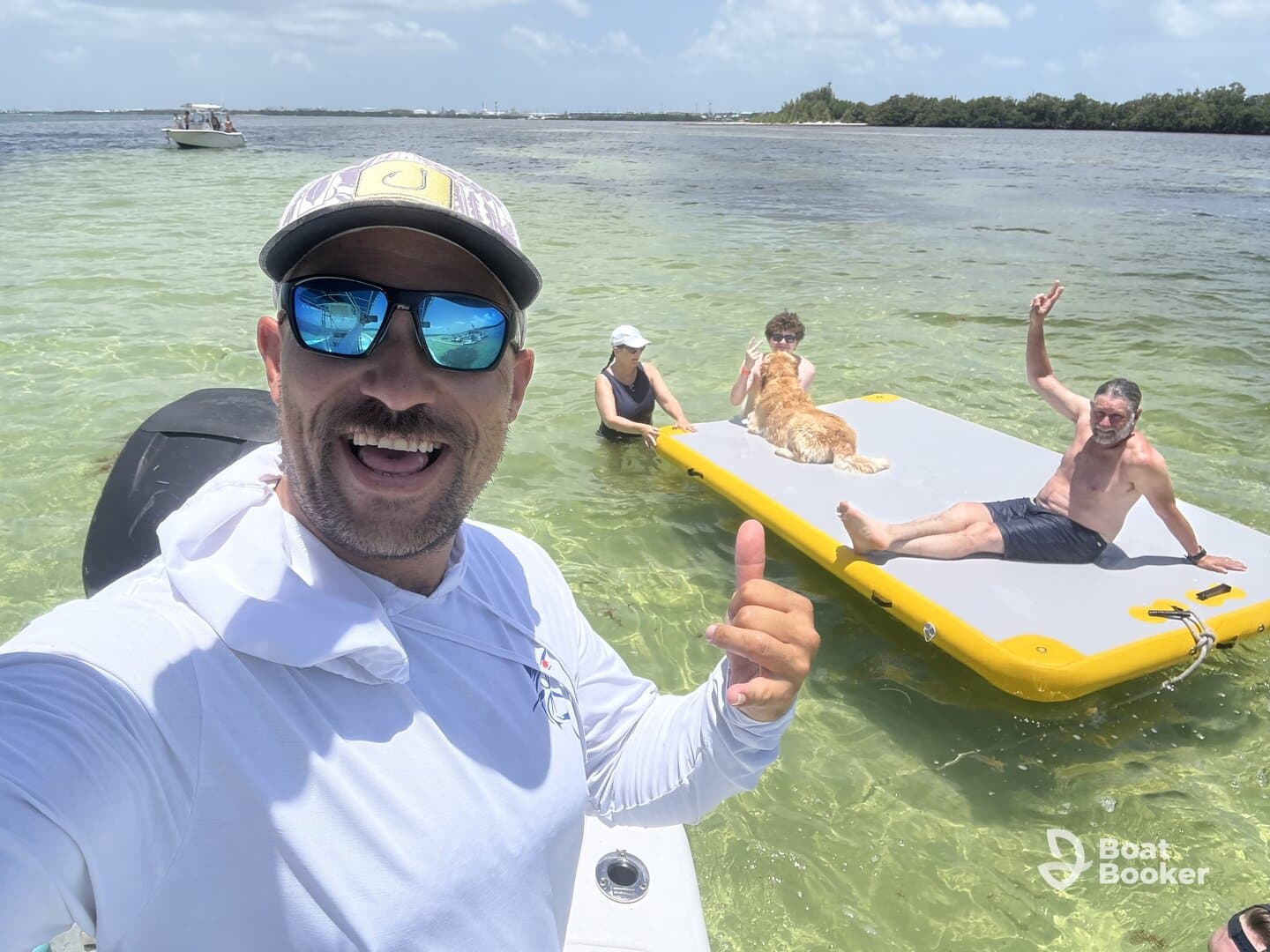 A joyful group enjoys a sunny day on the water, featuring a floating mat and a friendly dog — perfect for summer fun and family outings.