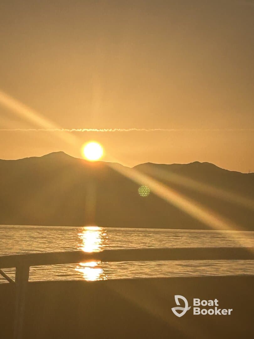 A serene sunset view over the water, with the sun reflecting on the surface, creating a picturesque backdrop for evening boat outings.