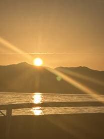 A serene sunset view over the water, with the sun reflecting on the surface, creating a picturesque backdrop for evening boat outings.