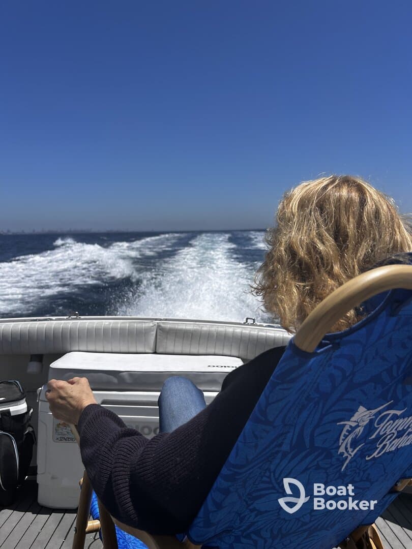 A guest enjoys a relaxing moment on a boat, taking in the scenic views while cruising through the open water — perfect for unwinding on a sunny day.