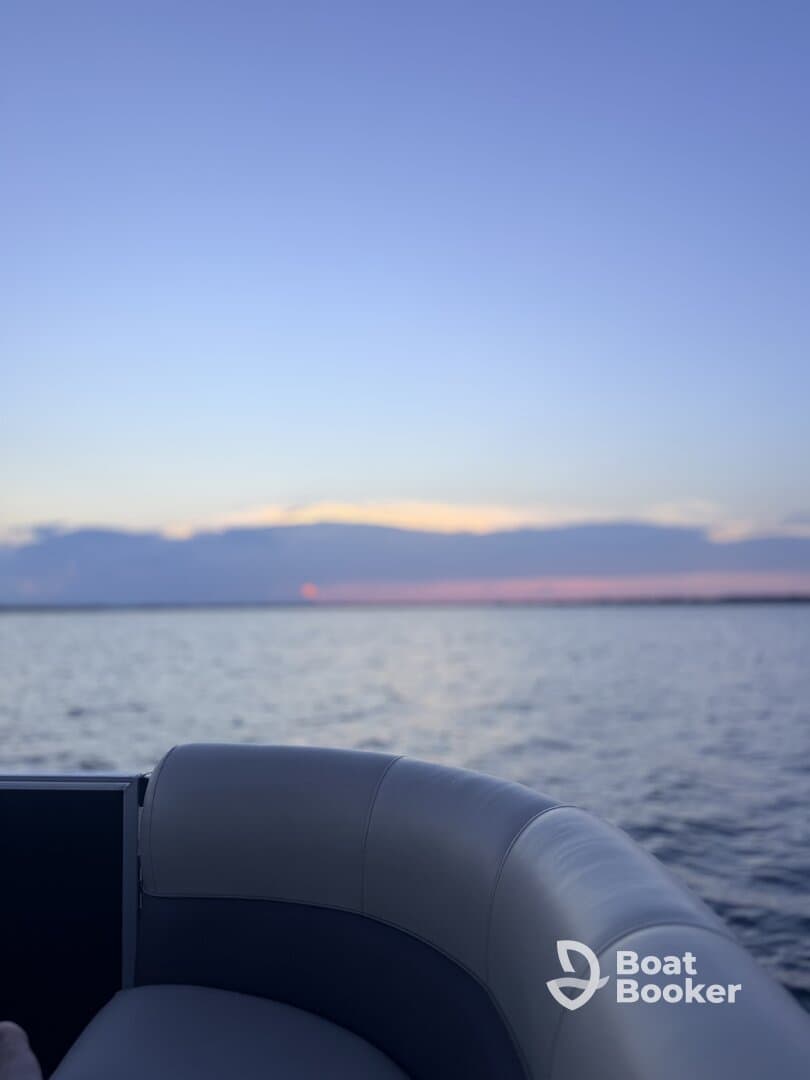 A serene view of a boat's seating area against a stunning sunset backdrop, perfect for relaxing evenings on the water.