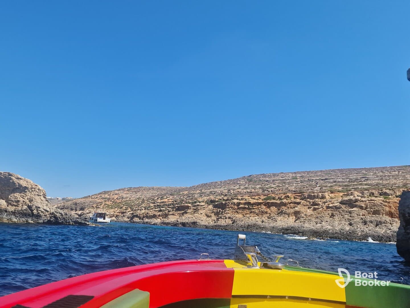 A vibrant view from the bow of a boat cruising along a stunning coastline, showcasing the natural beauty of the rocky landscape and clear blue waters.