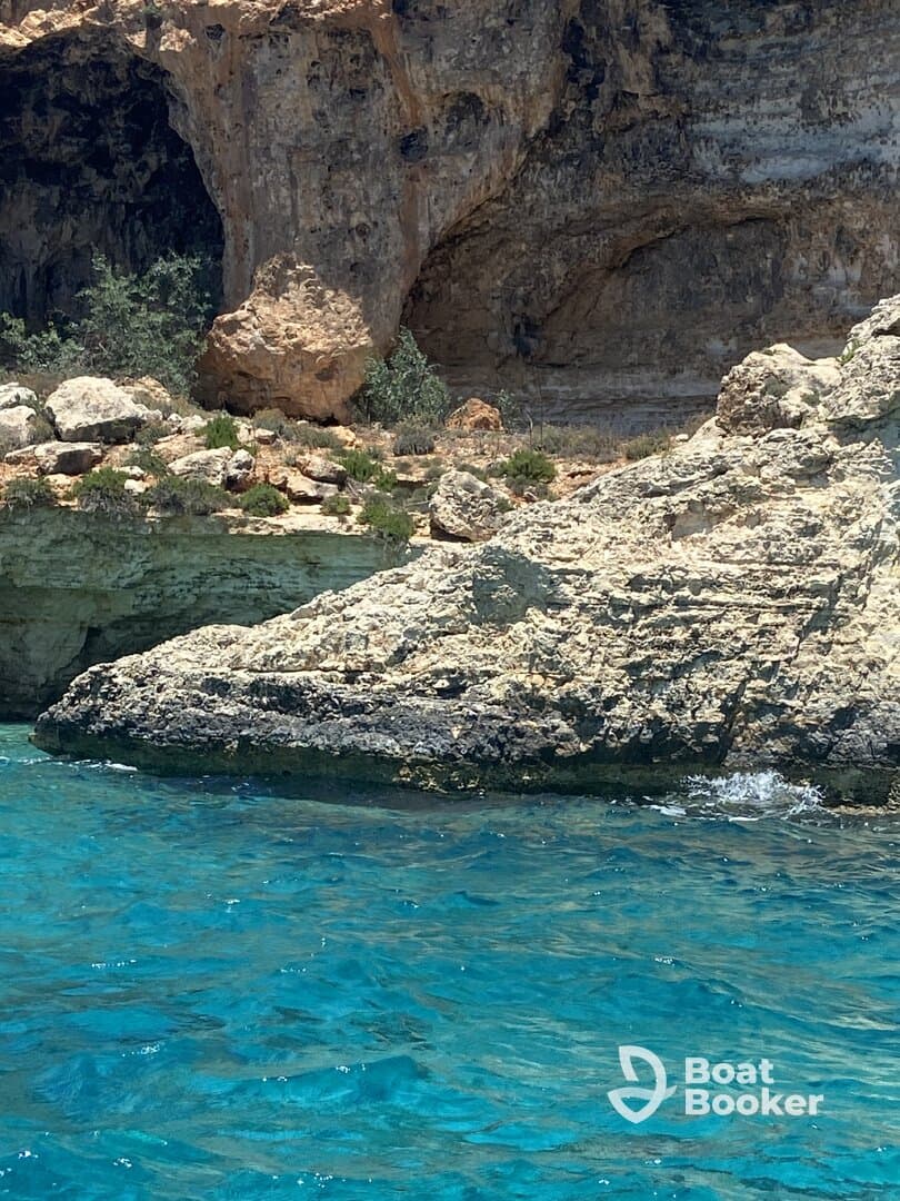 A scenic view of rocky cliffs and clear turquoise waters, but the image lacks clarity and focus.