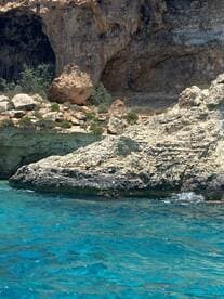A scenic view of rocky cliffs and clear turquoise waters, but the image lacks clarity and focus.