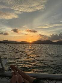 A couple enjoys a romantic sunset view from the deck of a yacht, creating a perfect backdrop for memorable moments on the water.