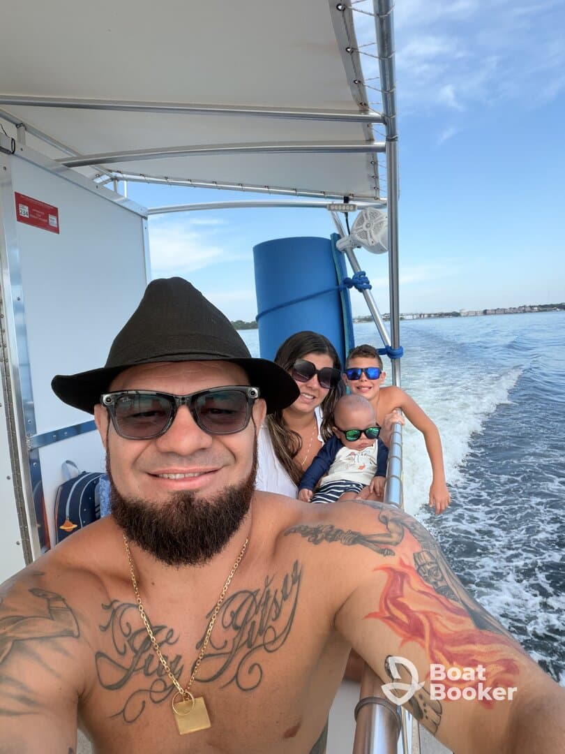 A joyful family enjoys a boat ride, capturing a fun moment together on the water — perfect for creating lasting memories during their adventure.