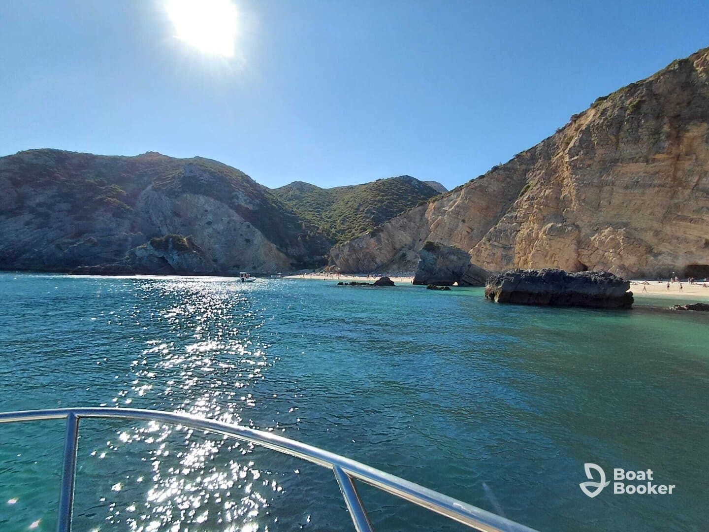 A stunning view of a serene coastline with sparkling waters and rocky formations, perfect for showcasing the beauty of a day on the water.