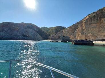 A stunning view of a serene coastline with sparkling waters and rocky formations, perfect for showcasing the beauty of a day on the water.
