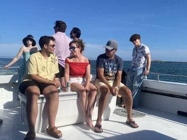 A lively group enjoys a day on the water, sharing drinks and laughter aboard a boat — perfect for social gatherings and celebrations.