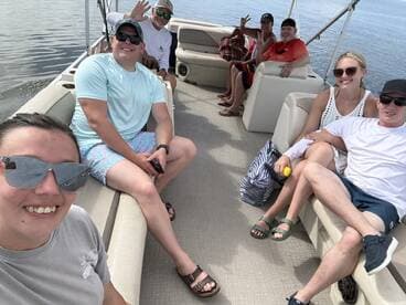 A cheerful group enjoys a fun day on a pontoon boat, capturing memories with smiles and laughter on the water.