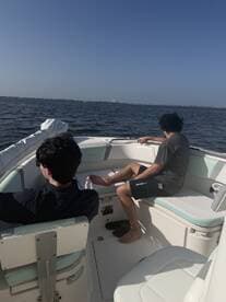 Two guests relax inside a modern boat, enjoying the serene water views. The interior features comfortable seating, perfect for a day out on the water.