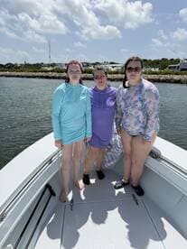 Three friends enjoy a sunny day on the boat, showcasing a fun and vibrant atmosphere perfect for summer outings.