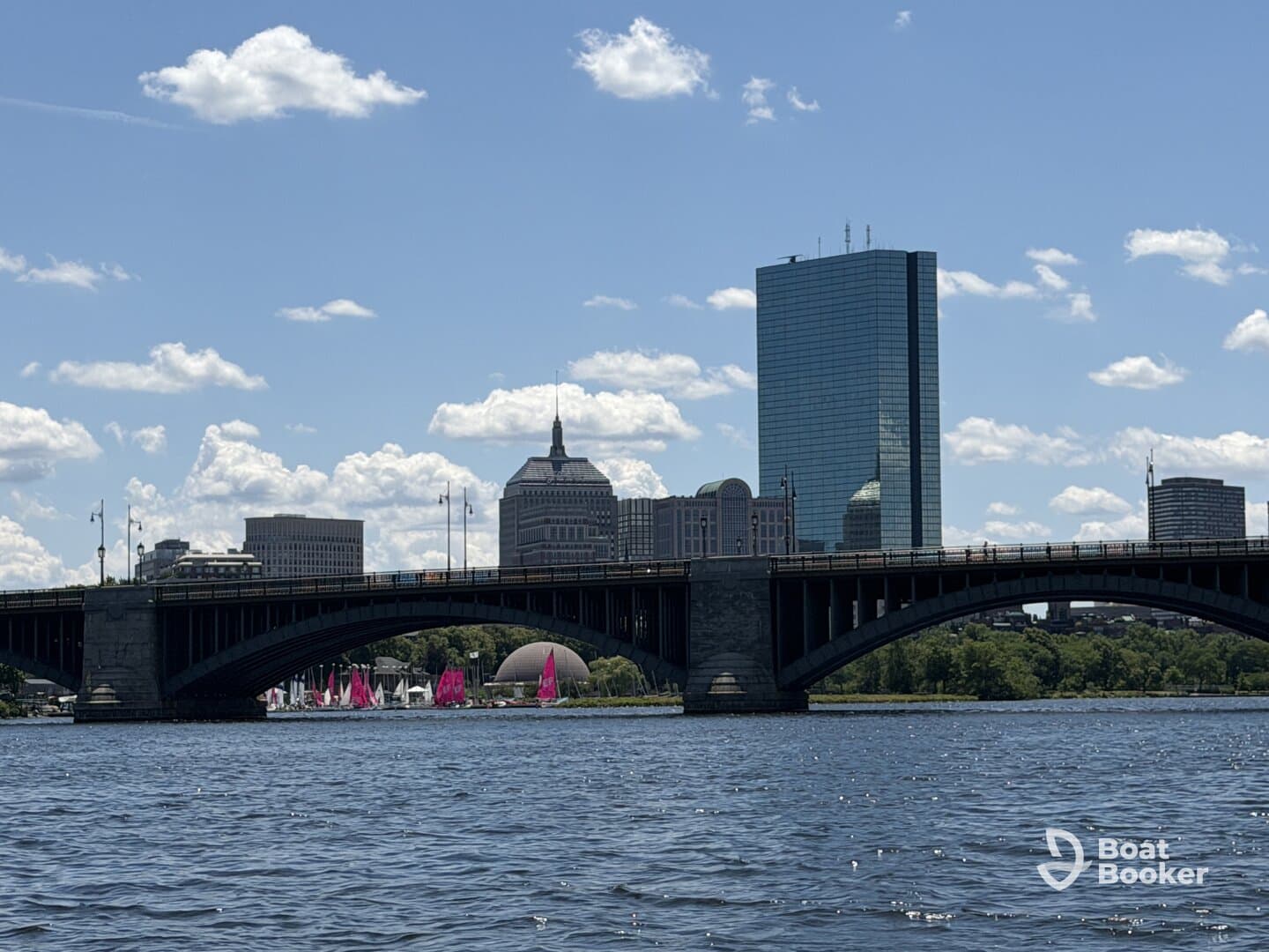 A picturesque view of a city skyline featuring a bridge and colorful sailboats on the water, perfect for showcasing urban boating adventures.