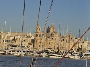 A picturesque view of a harbor filled with boats, showcasing stunning architecture in the background — a perfect destination for maritime enthusiasts.