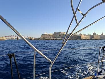 A picturesque view from a boat showcasing the coastline and historic architecture, perfect for capturing the essence of a sailing adventure.