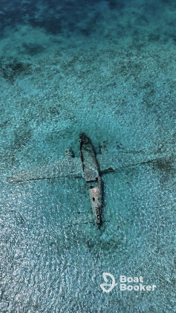 Aerial view of a shipwreck submerged in crystal-clear waters, showcasing the beauty of underwater exploration and marine history.