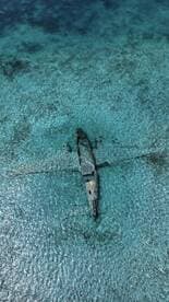 Aerial view of a shipwreck submerged in crystal-clear waters, showcasing the beauty of underwater exploration and marine history.