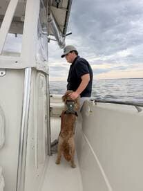 A young boy enjoys a moment with his dog aboard a boat, showcasing the joy of companionship on the water.