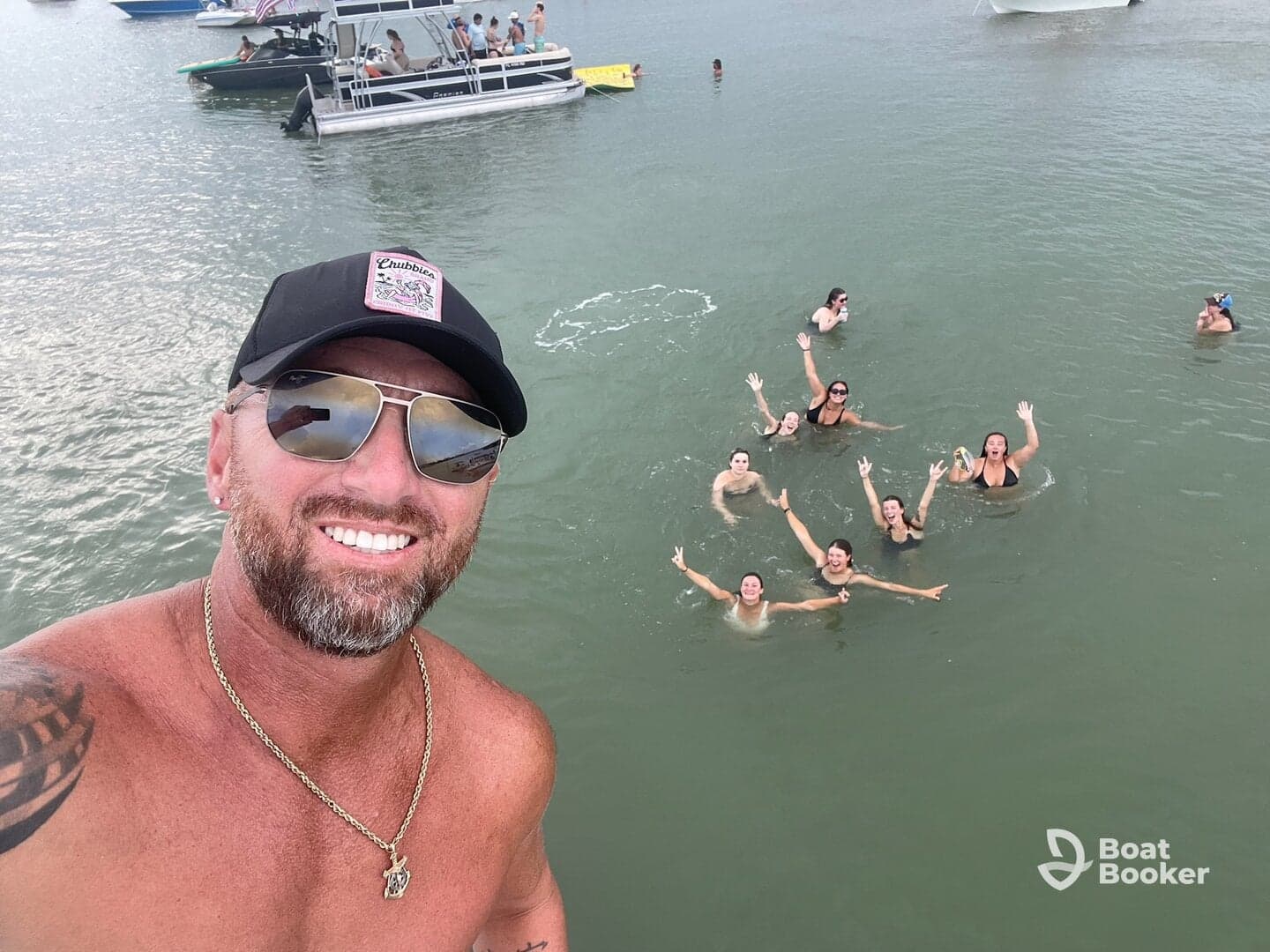 A lively group enjoys a fun day swimming in the water, with boats anchored nearby — perfect for summer parties and water adventures.