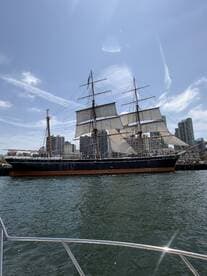 A majestic tall ship with sails raised, docked in a bustling harbor, showcasing classic maritime architecture against a clear blue sky.