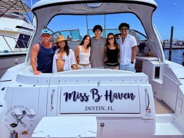A cheerful group of friends poses aboard the 'Miss B Haven' yacht in Destin, FL, capturing the essence of fun and celebration on the water.