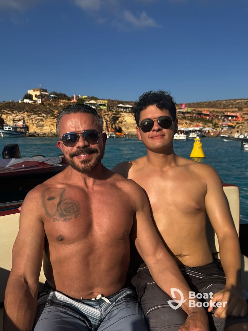 Two friends enjoy a sunny day on the water, capturing a moment of joy aboard a boat with a scenic backdrop.