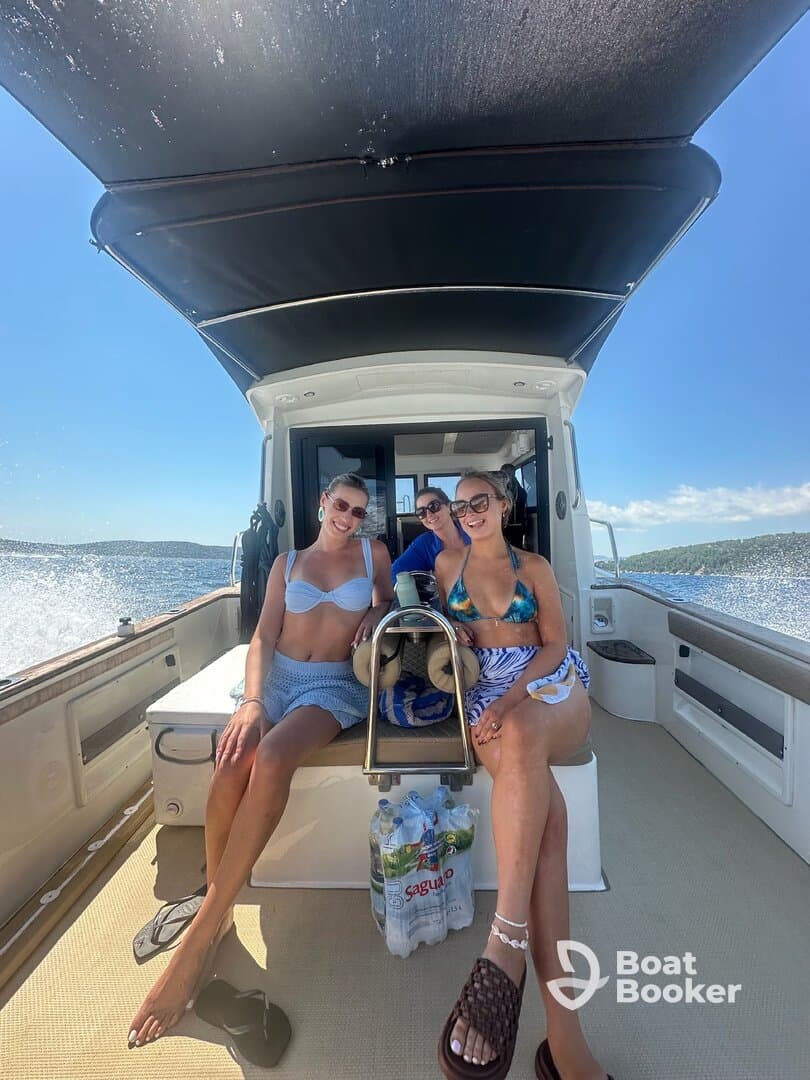 Three friends enjoy a sunny day on a boat, capturing the essence of summer fun and friendship on the water.