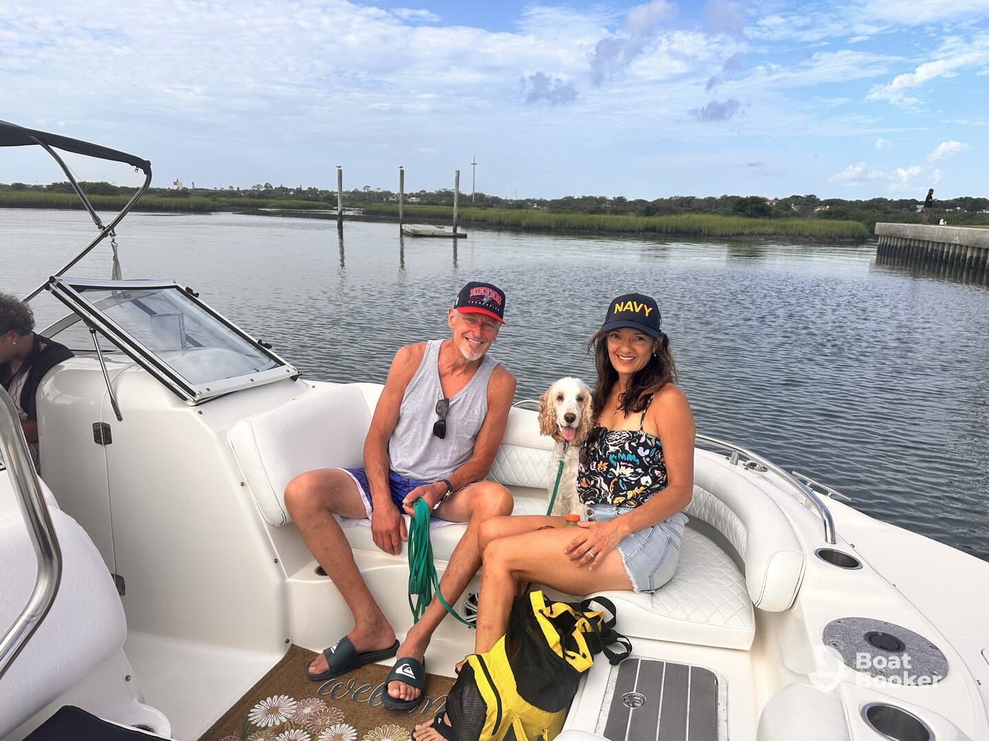 A cheerful group enjoys a relaxing moment on a boat with their dog, surrounded by scenic waters — perfect for a day of fun and companionship on the water.