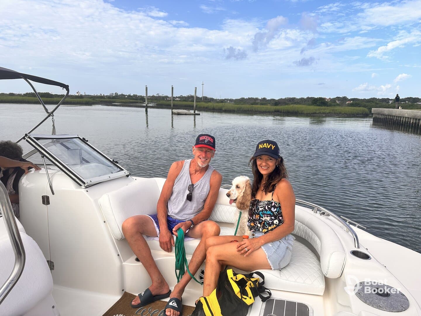A couple enjoys a relaxing day on the water with their dog, showcasing the perfect blend of companionship and leisure aboard their boat.