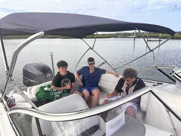 A group of friends enjoys a relaxing moment on a boat, surrounded by calm waters — perfect for a day of fun and camaraderie on the water.