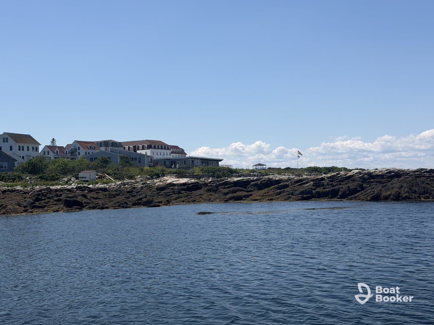 A picturesque view of a rocky coastline with charming buildings in the background, showcasing the beauty of coastal landscapes.