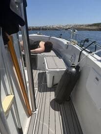 A person relaxes on the deck of a boat, showcasing the comfortable seating area — perfect for lounging during a day on the water.