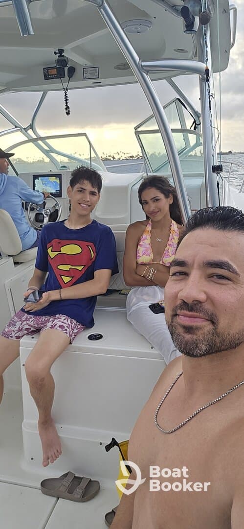 A family enjoys a fun day on the boat, capturing a memorable moment together with smiles and laughter.