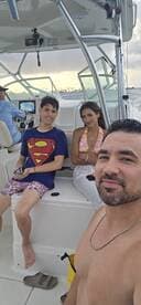 A family enjoys a fun day on the boat, capturing a memorable moment together with smiles and laughter.