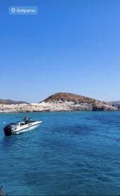 A speedboat navigates the crystal-clear waters near Antiparos, showcasing the stunning coastal scenery and inviting adventure on the open sea.