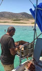 A chef prepares delicious grilled skewers on a boat, with clear turquoise waters in the background — perfect for onboard dining experiences during a day at sea.