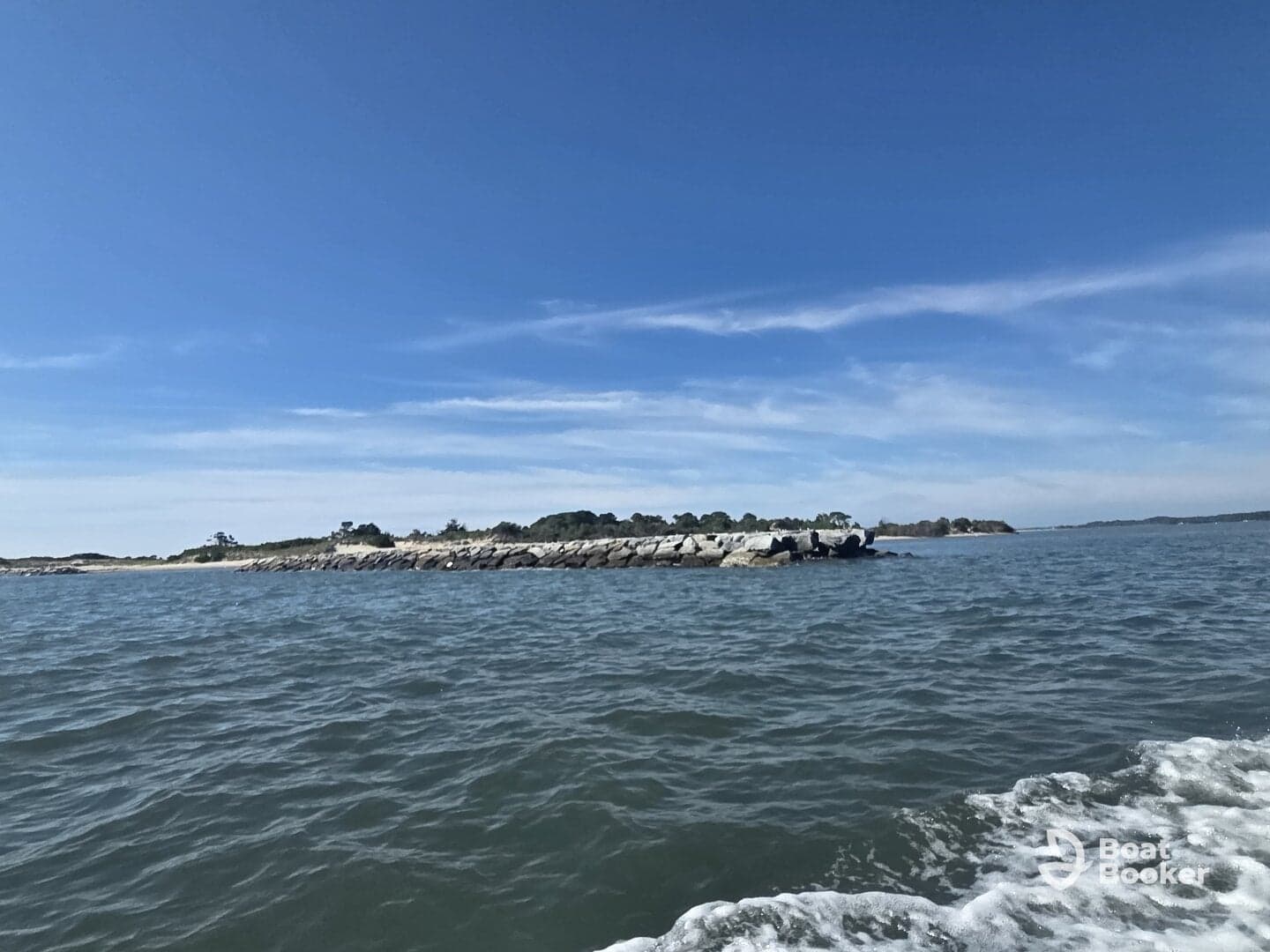 A picturesque view of a rocky coastline under a clear blue sky, showcasing the beauty of the surrounding waters and natural landscape.
