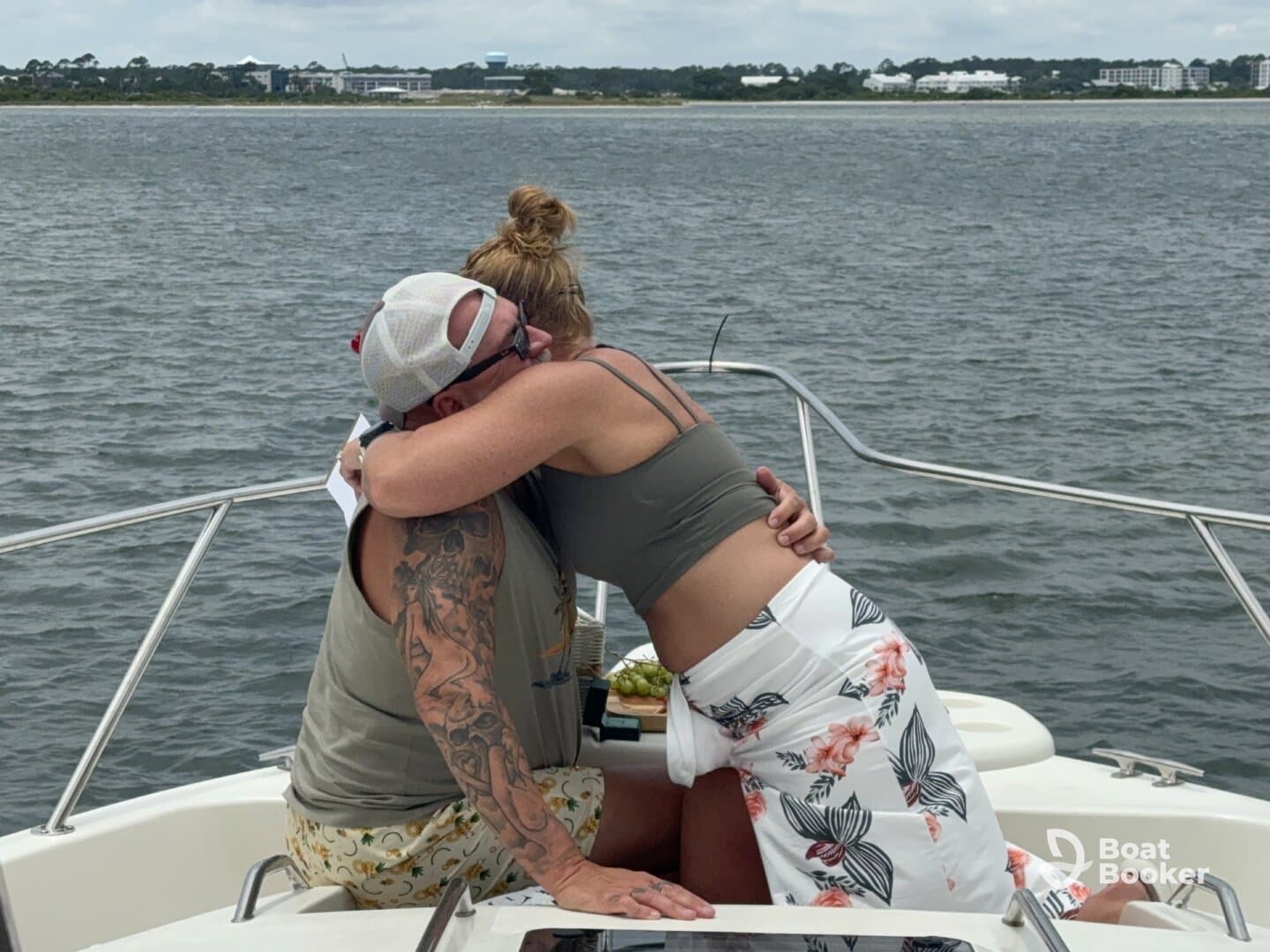 A couple shares a heartfelt hug on the deck of a boat, capturing a moment of joy and connection amidst the scenic waters.