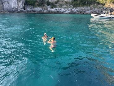 A couple enjoys snorkeling in crystal-clear waters, surrounded by stunning rock formations — a perfect moment for adventure seekers.