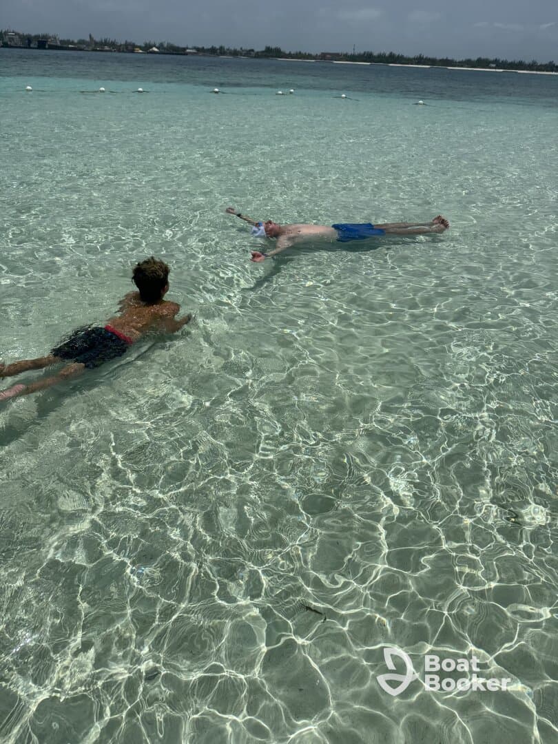 A child and an adult enjoy a refreshing swim in crystal-clear waters, showcasing the perfect setting for a fun day of snorkeling and relaxation.