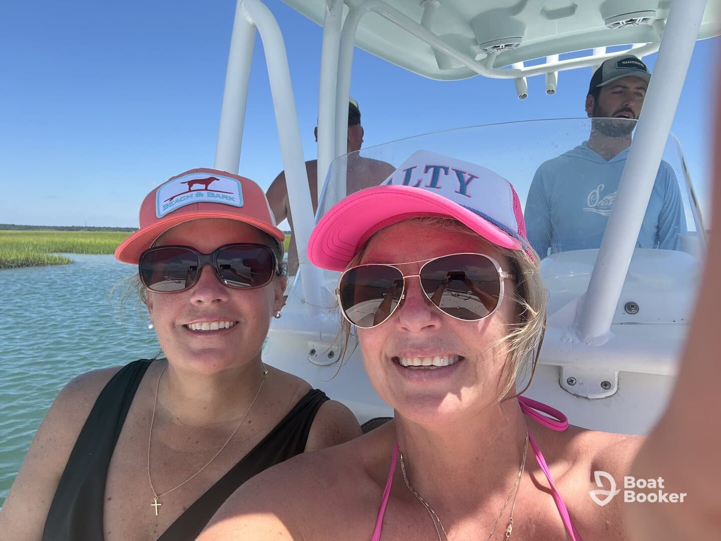 Two friends take a cheerful selfie aboard a boat, enjoying a sunny day on the water — perfect for capturing memorable moments during a boating adventure.