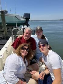A cheerful family poses together on a boat, enjoying a sunny day on the water — perfect for creating lasting memories during their boating adventures.