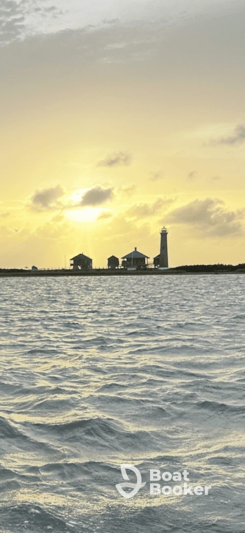 A stunning sunset view featuring a lighthouse and coastal buildings, creating a picturesque backdrop over the water — perfect for capturing the beauty of maritime landscapes.
