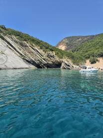 A picturesque view of a serene coastline with a boat anchored nearby, showcasing the beauty of nature and perfect for a relaxing day on the water.