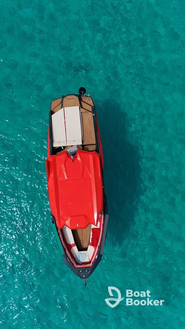 A stunning aerial view of a sleek red speedboat gliding over crystal-clear turquoise waters, perfect for thrilling adventures on the sea.