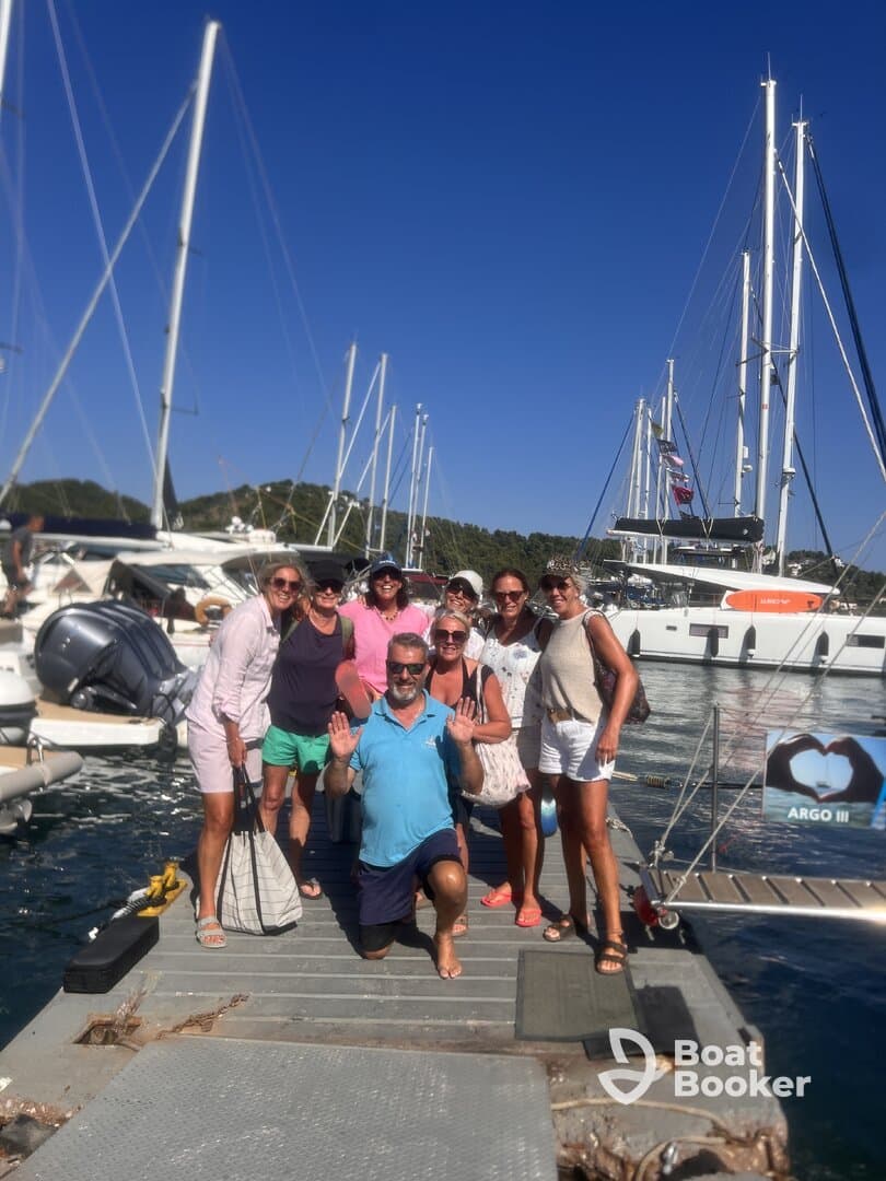 A cheerful group poses for a photo on the dock, celebrating their time aboard the yacht ARGO III — perfect for memorable boating adventures.