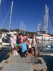 A cheerful group poses for a photo on the dock, celebrating their time aboard the yacht ARGO III — perfect for memorable boating adventures.