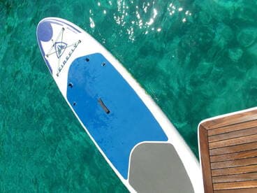A paddleboard rests on clear turquoise waters, showcasing the perfect setup for a day of fun on the water.