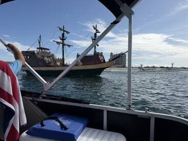 A scenic view of a pirate ship sailing by, captured from another boat — a perfect moment showcasing the fun of on-water adventures.